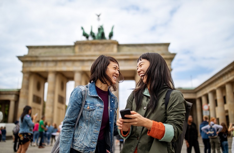 Cheerful friends standing against Brandenburg Gate